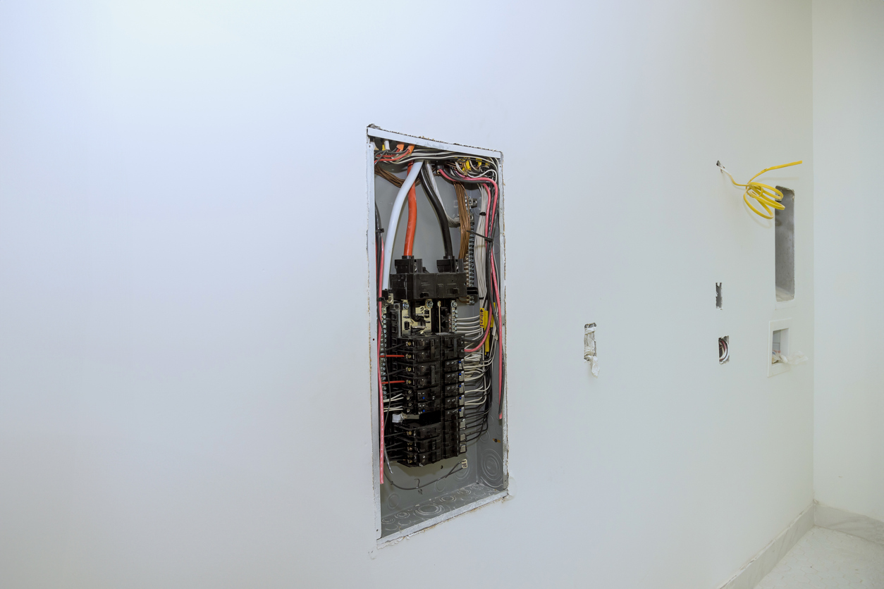 Electrical power control panel switch box is mounted to wooden frame beams on wall with a circuit breaker mounted in it Panel Upgrade Near Me