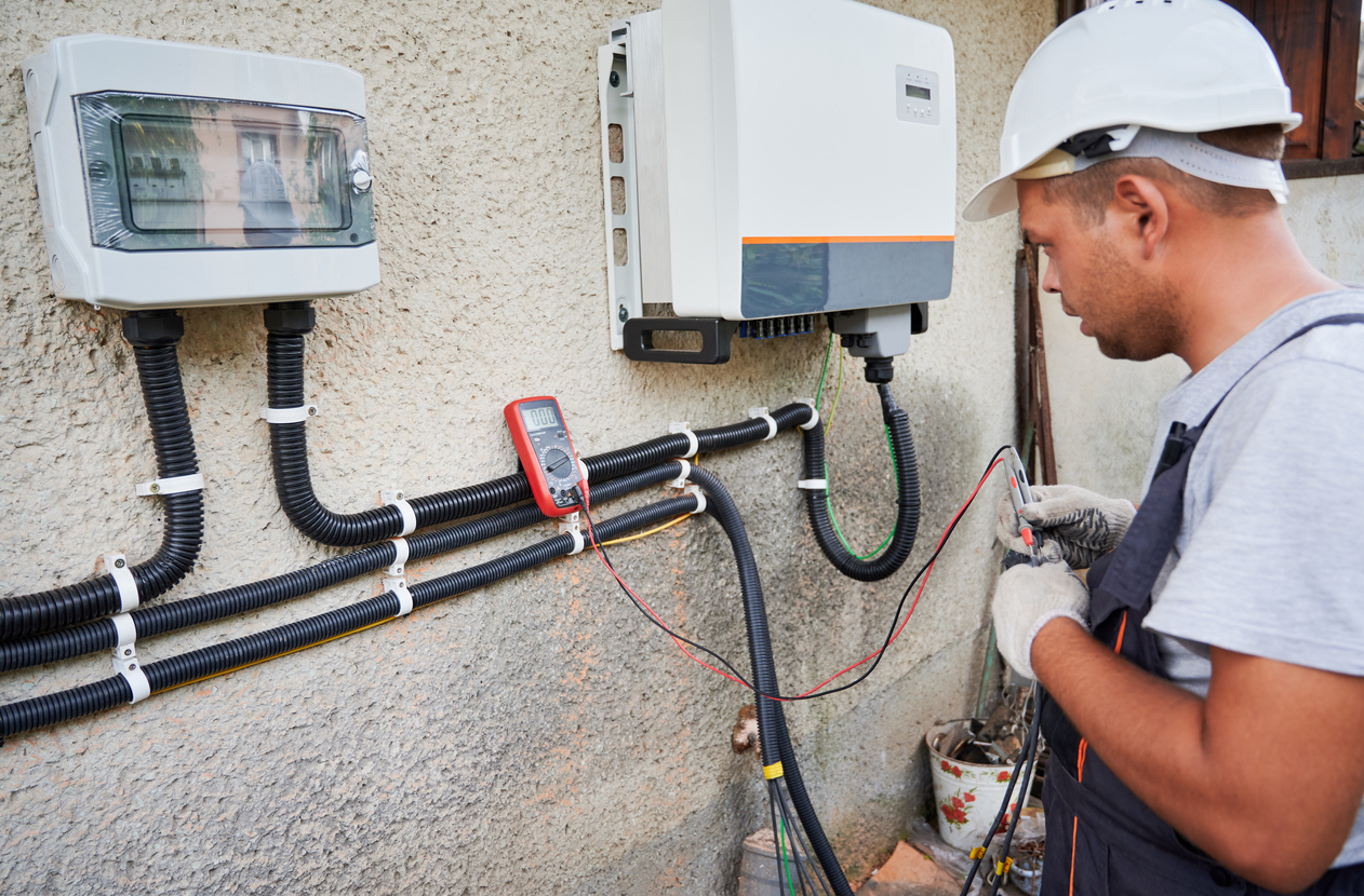 Electrician installing solar panel system, wiring inverter and electric box Whole House Generator Installers Highlands Ranch