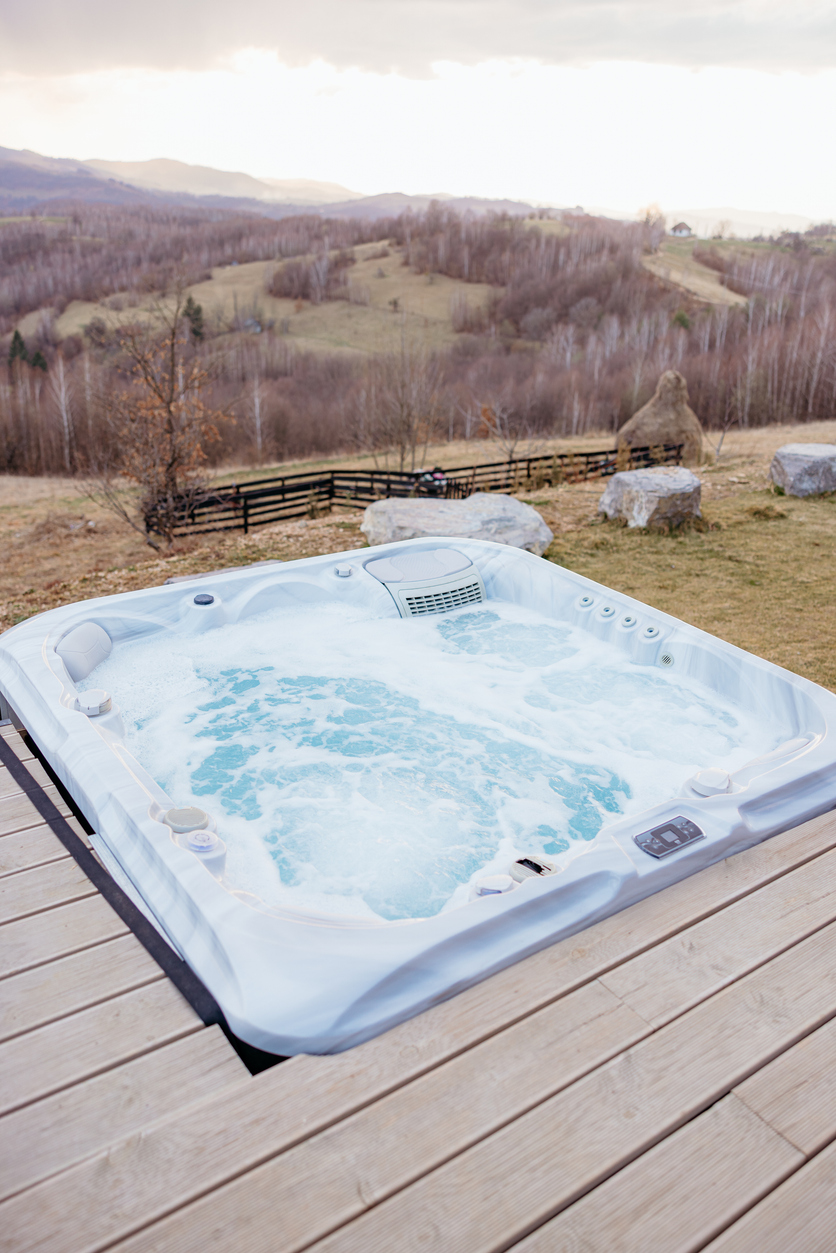 Steaming outdoor hot tub overlooking a serene mountain view Littleton Hot Tub Electrician